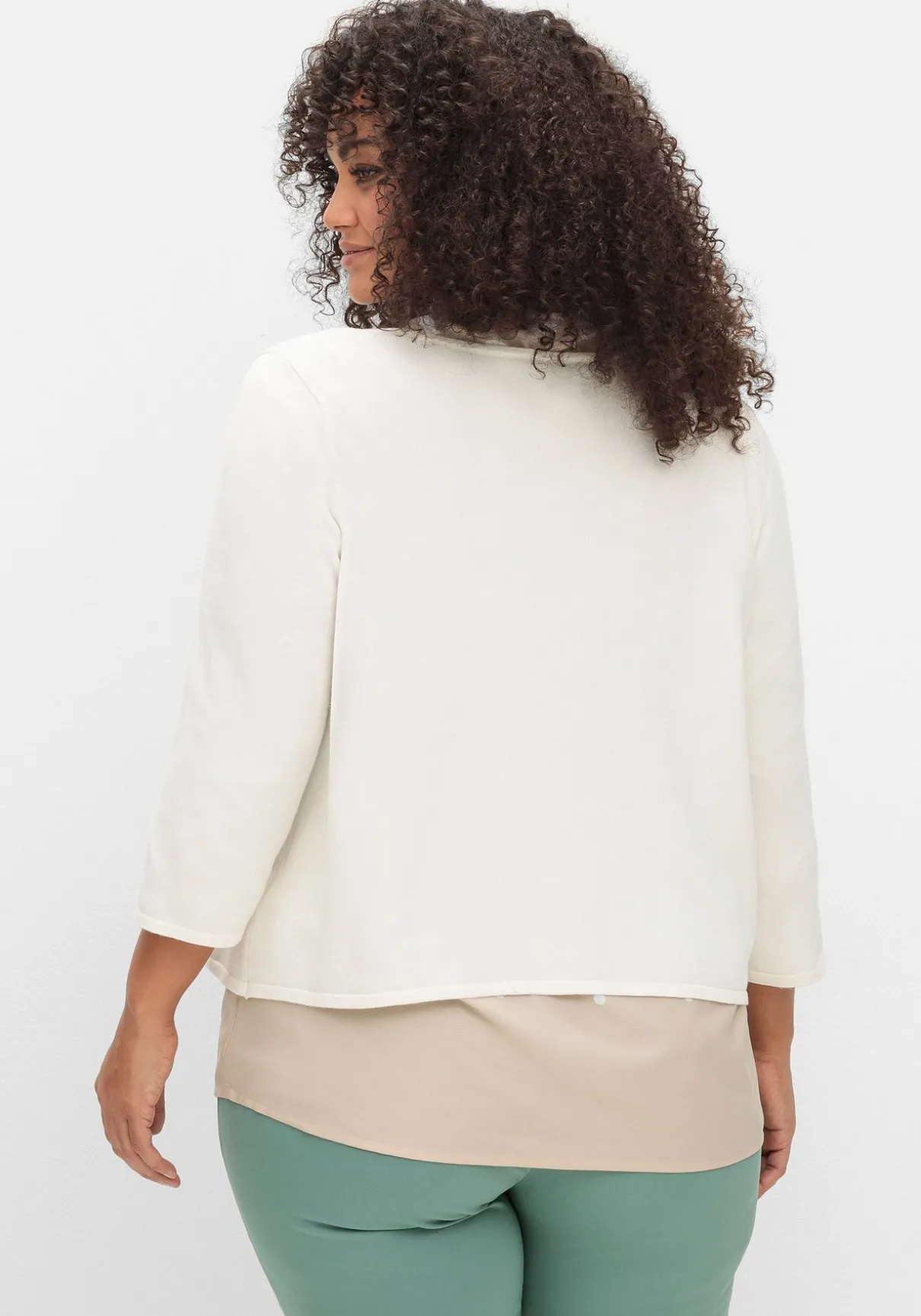 Kurze Strickjacke mit Zierspange am Ausschnitt