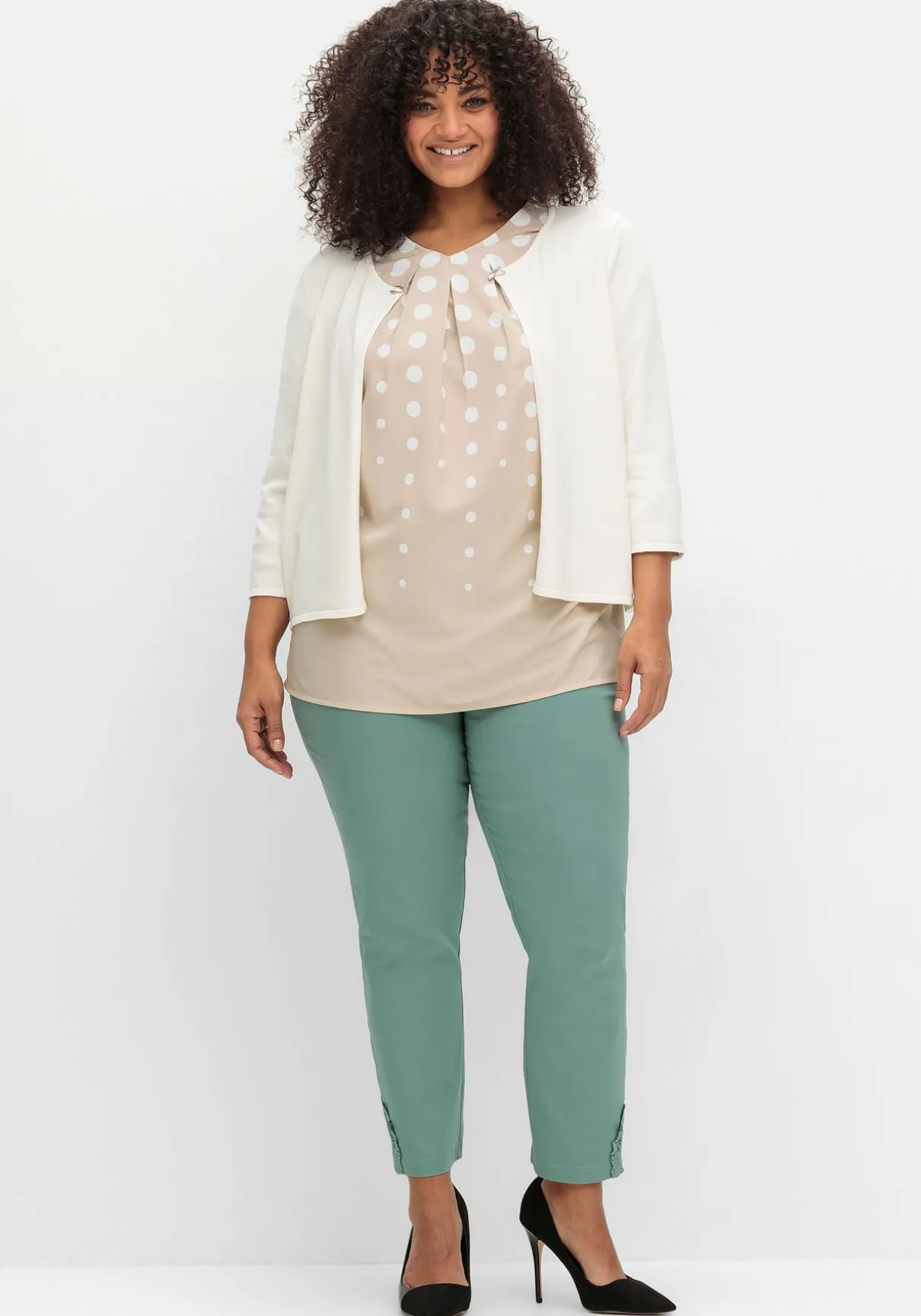 Kurze Strickjacke mit Zierspange am Ausschnitt