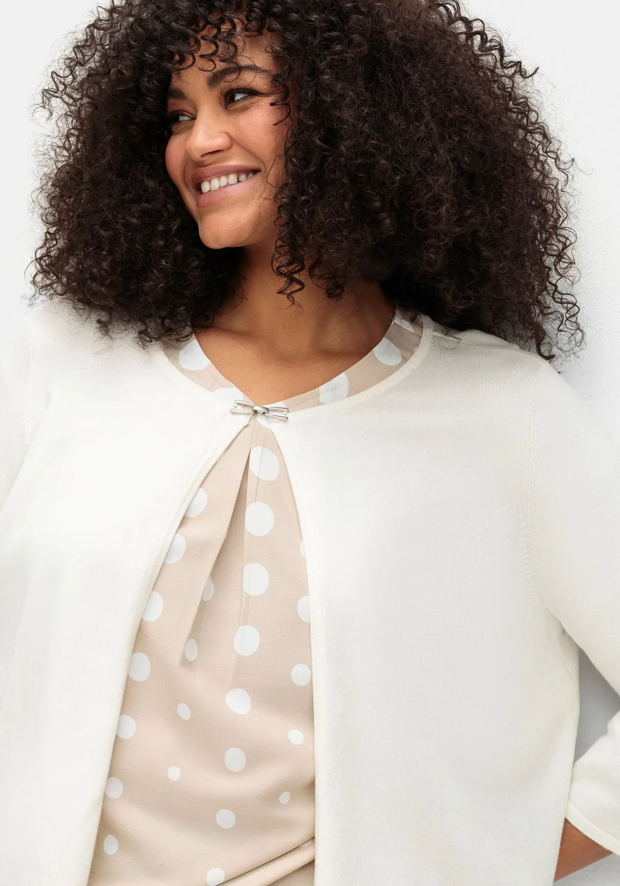 Kurze Strickjacke mit Zierspange am Ausschnitt