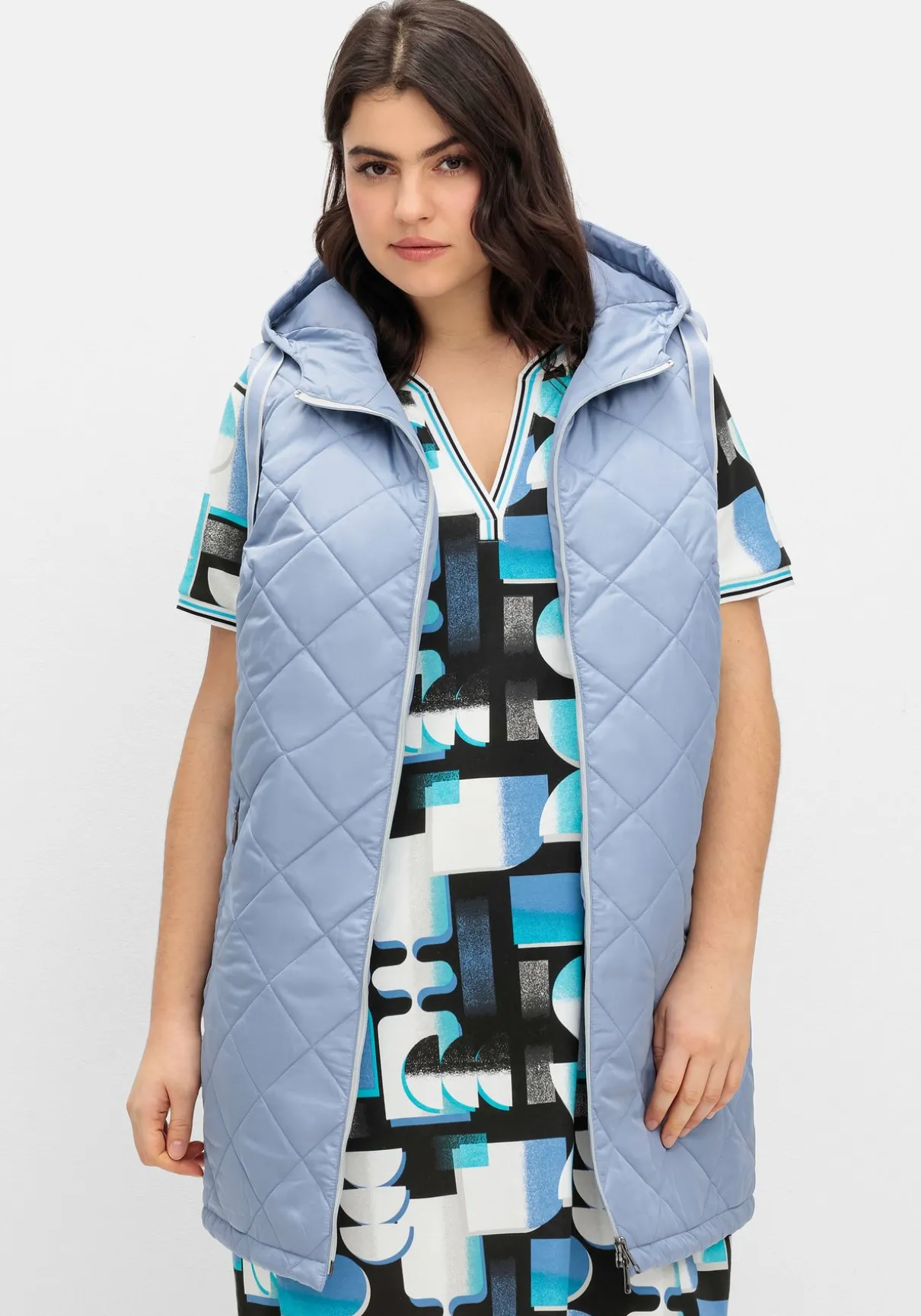 Lange Steppweste mit Kapuze und Kontrastdetails